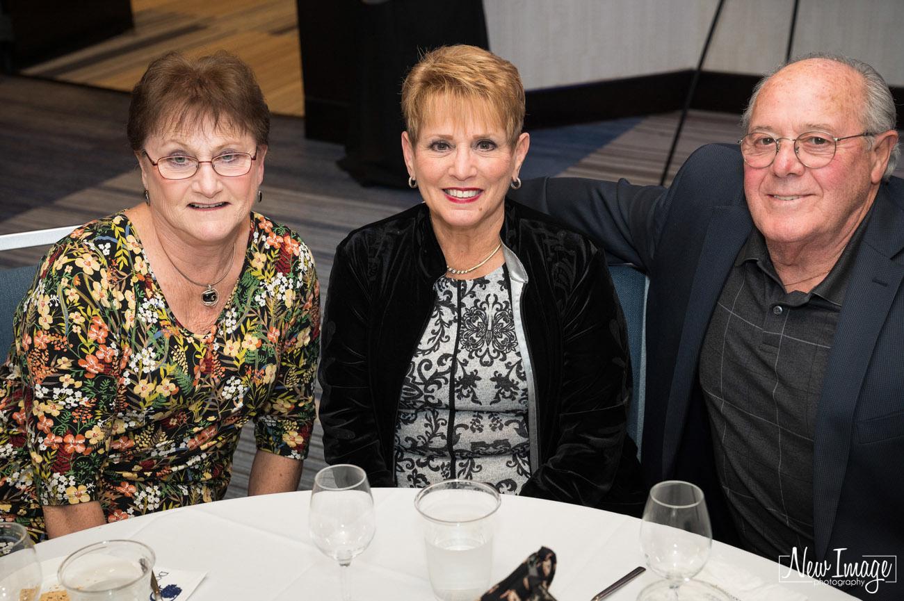 Three older adults sitting at a table.