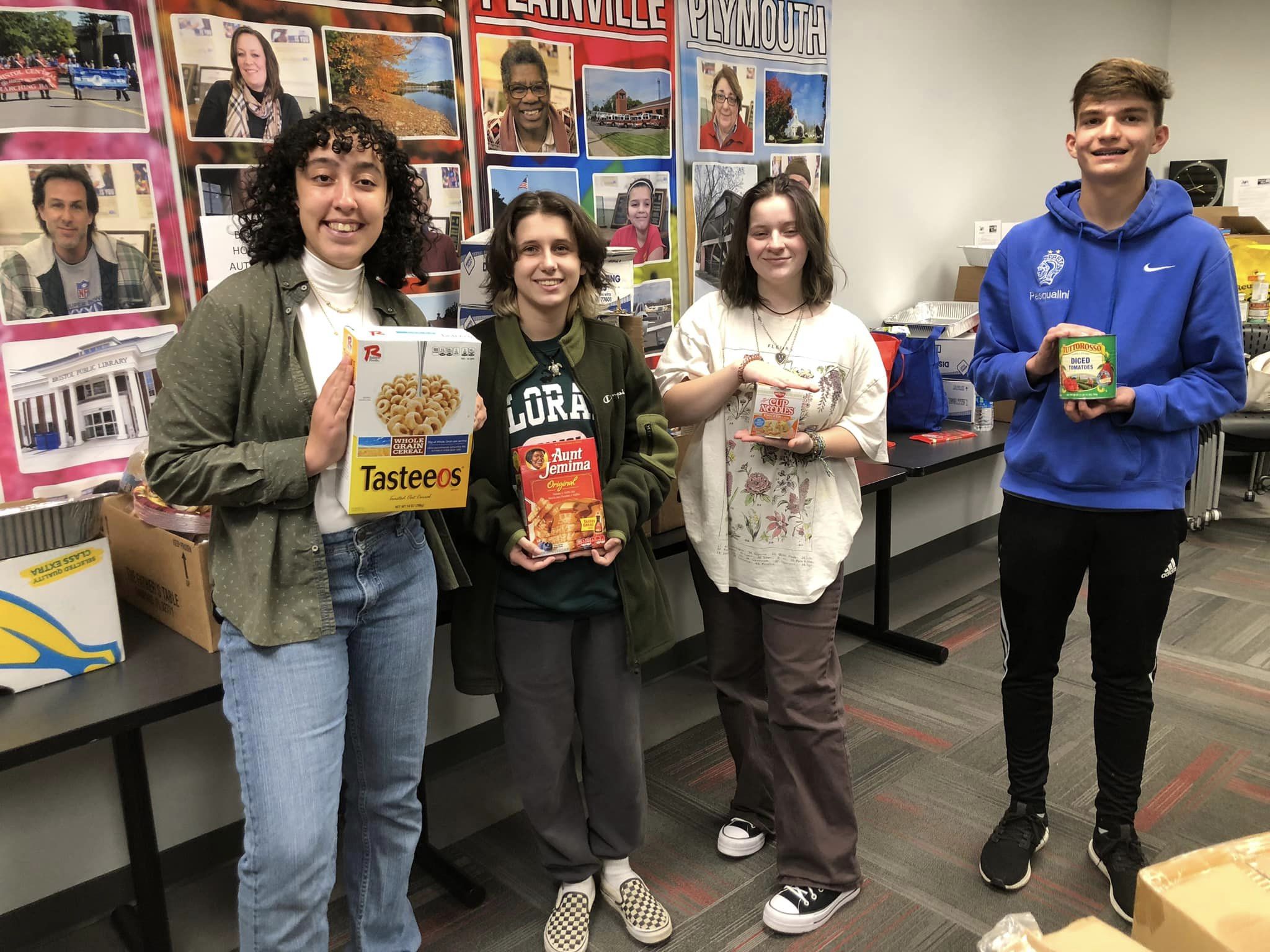Four high school students donating nonperishable food.