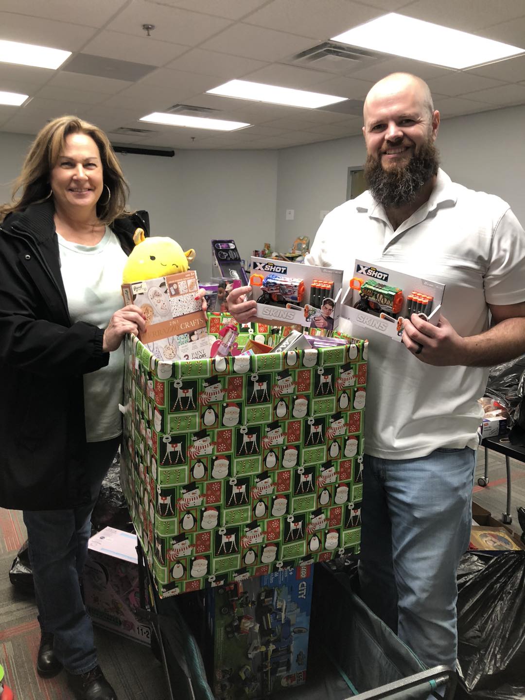 Two adults with large box of donated toys