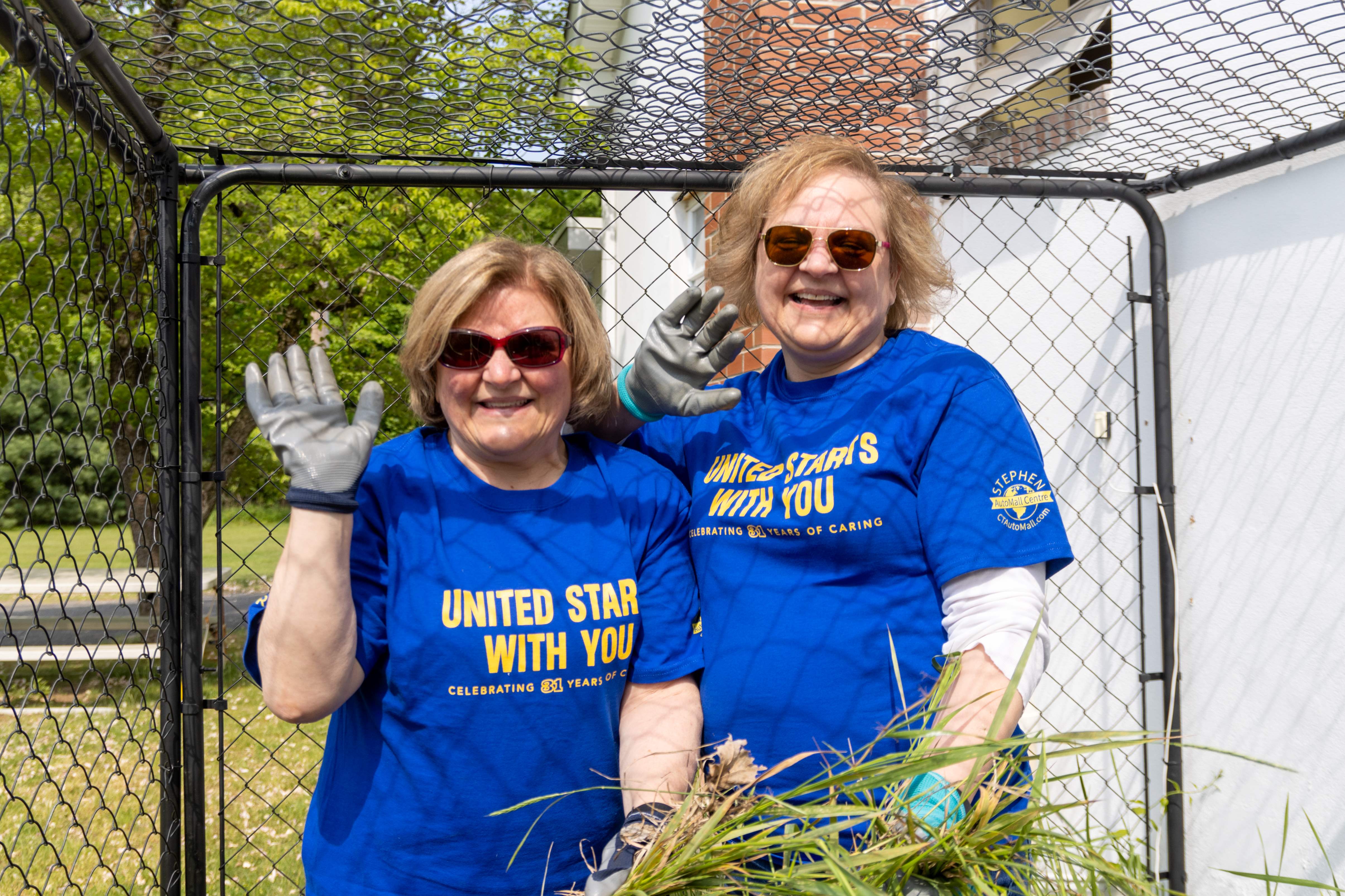 Cigna volunteers pulling weeds at Bristol Adult Resource Center.